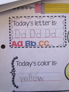 Alphabet and color word practice on a daily notebook page.